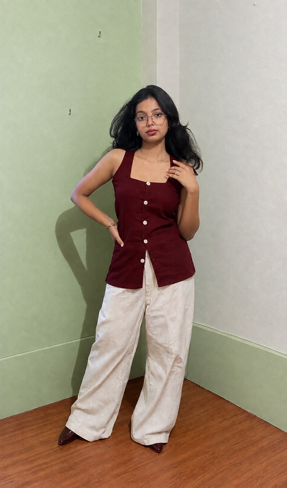 Full-length view of the Tara sleeveless maroon top worn with wide-leg trousers